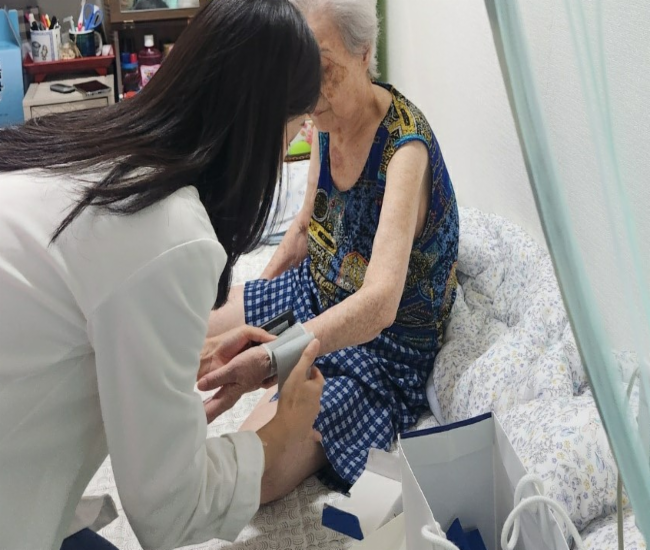 보건 전문가가 지역주민 혈압을 측정 중인 모습